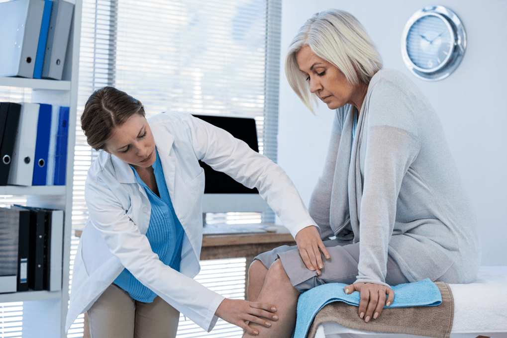 A patient with arthrosis who requires therapy is being examined by a doctor